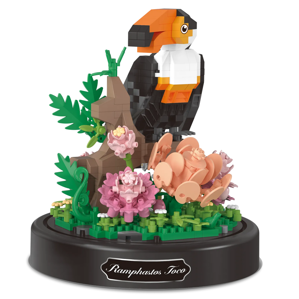 Produktfoto der Balody Miniblocks Tukan, sitzend auf einem Zweig mit Blumen, unter einer Glocke