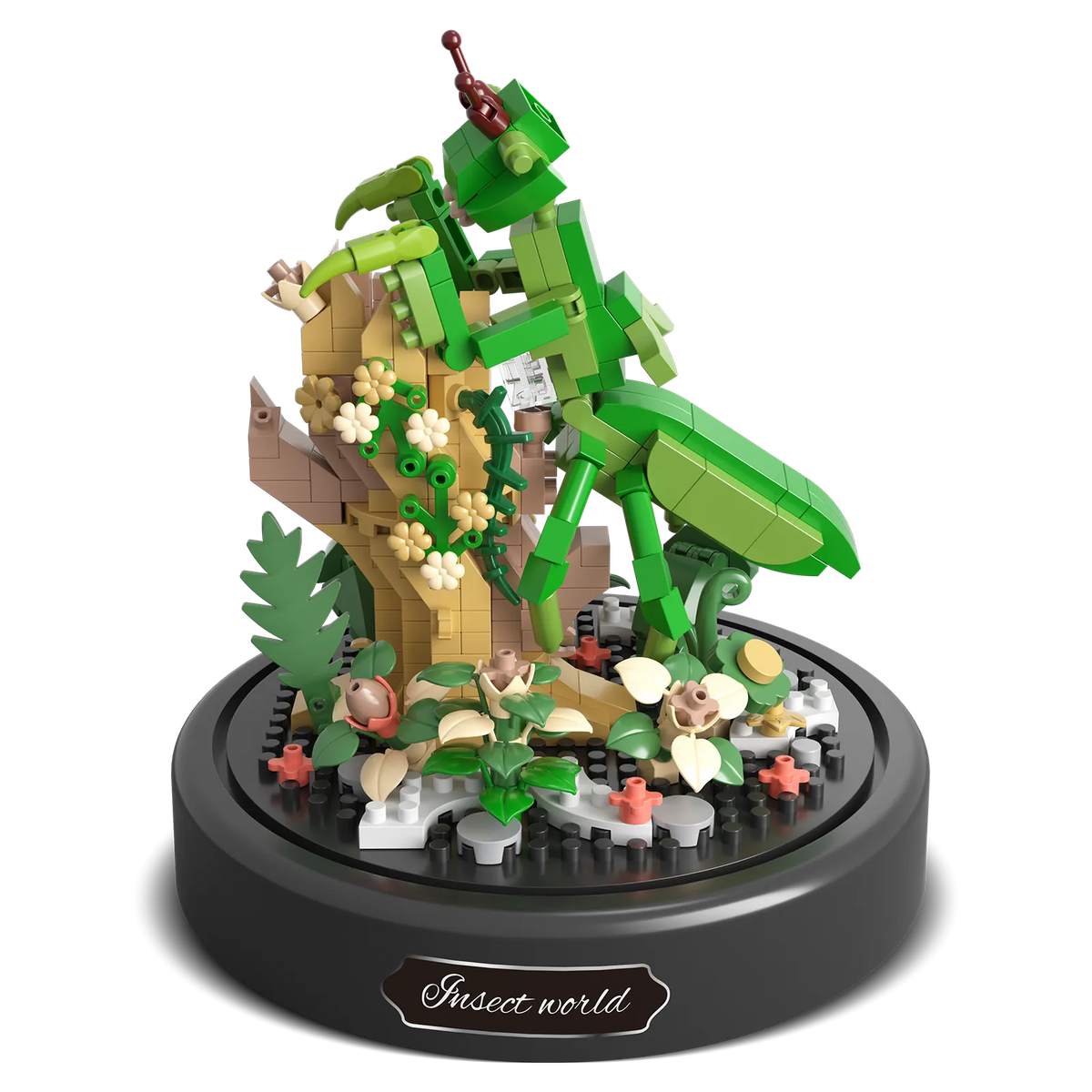 Produktfoto der Balody Miniblocks Gottesanbeterin auf einem Zweig mit Blumen und pflanzlichem Boden, unter einer Glocke