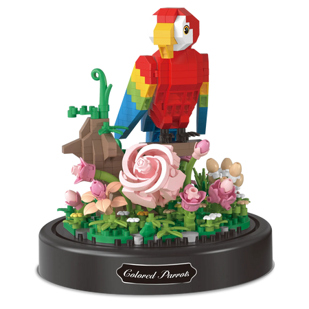 Produktfoto der Balody Miniblocks roter Papagei sitzend auf einem Zweig mit Blumen unter einer Glocke