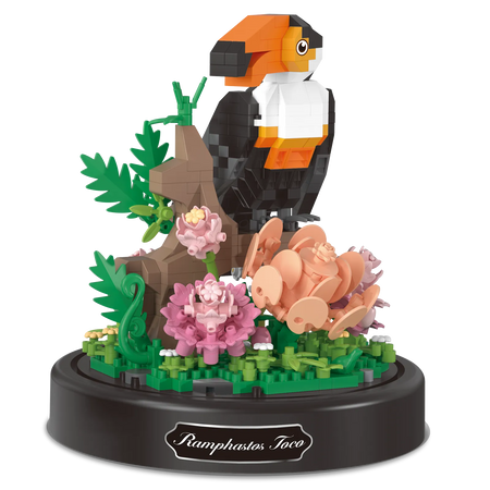 Produktfoto der Balody Miniblocks Tukan, sitzend auf einem Zweig mit Blumen, unter einer Glocke