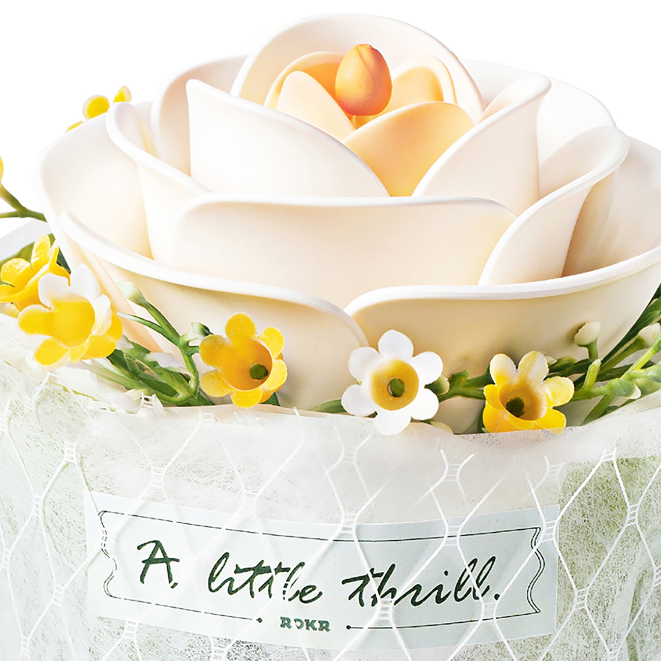 Nahaufnahme der weißen Blume und der Stoffumhüllung mit Text von der Robotime Camellia
