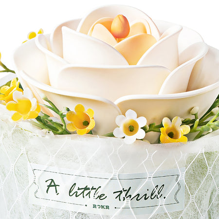 Nahaufnahme der weißen Blume und der Stoffumhüllung mit Text von der Robotime Camellia
