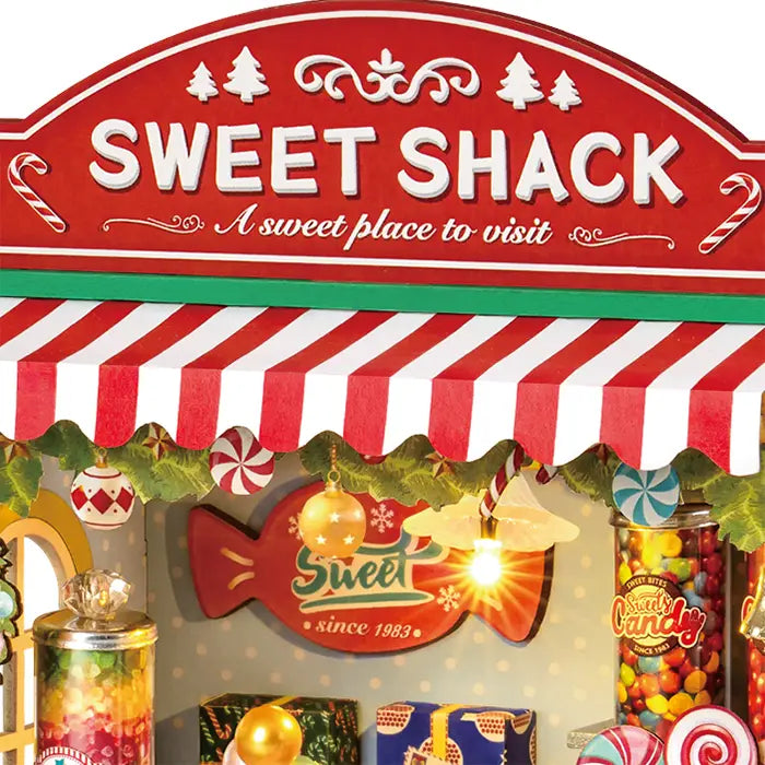 Nahaufnahme des Ladenschilds und der Markise des Robotime Christmas Candy Stand