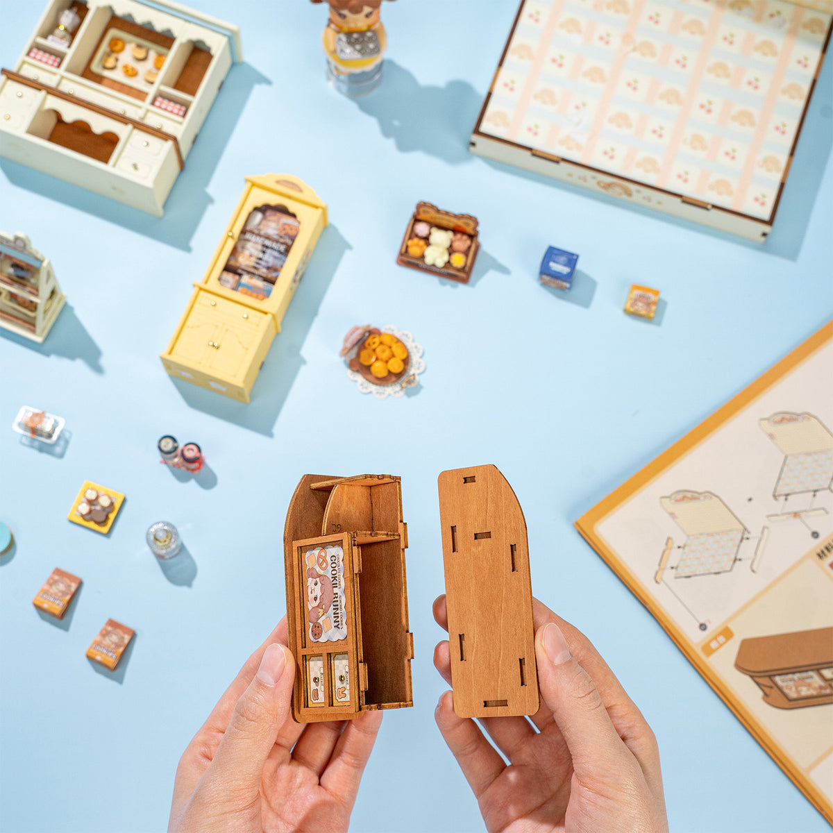 Eine Person baut die Ladentheke des Robotime Cookii Bunny’s Cookie Shop