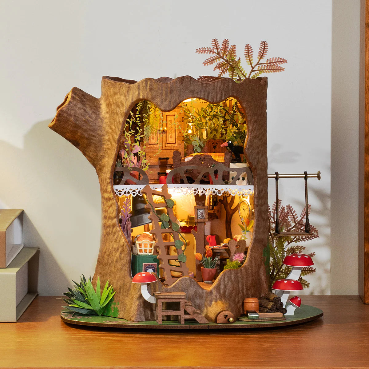 Atmosphärische Präsentation der Robotime Fairytale Tree House, Bausatz für ein zweistöckiges Miniaturhaus in einem hohlen Baumstamm
