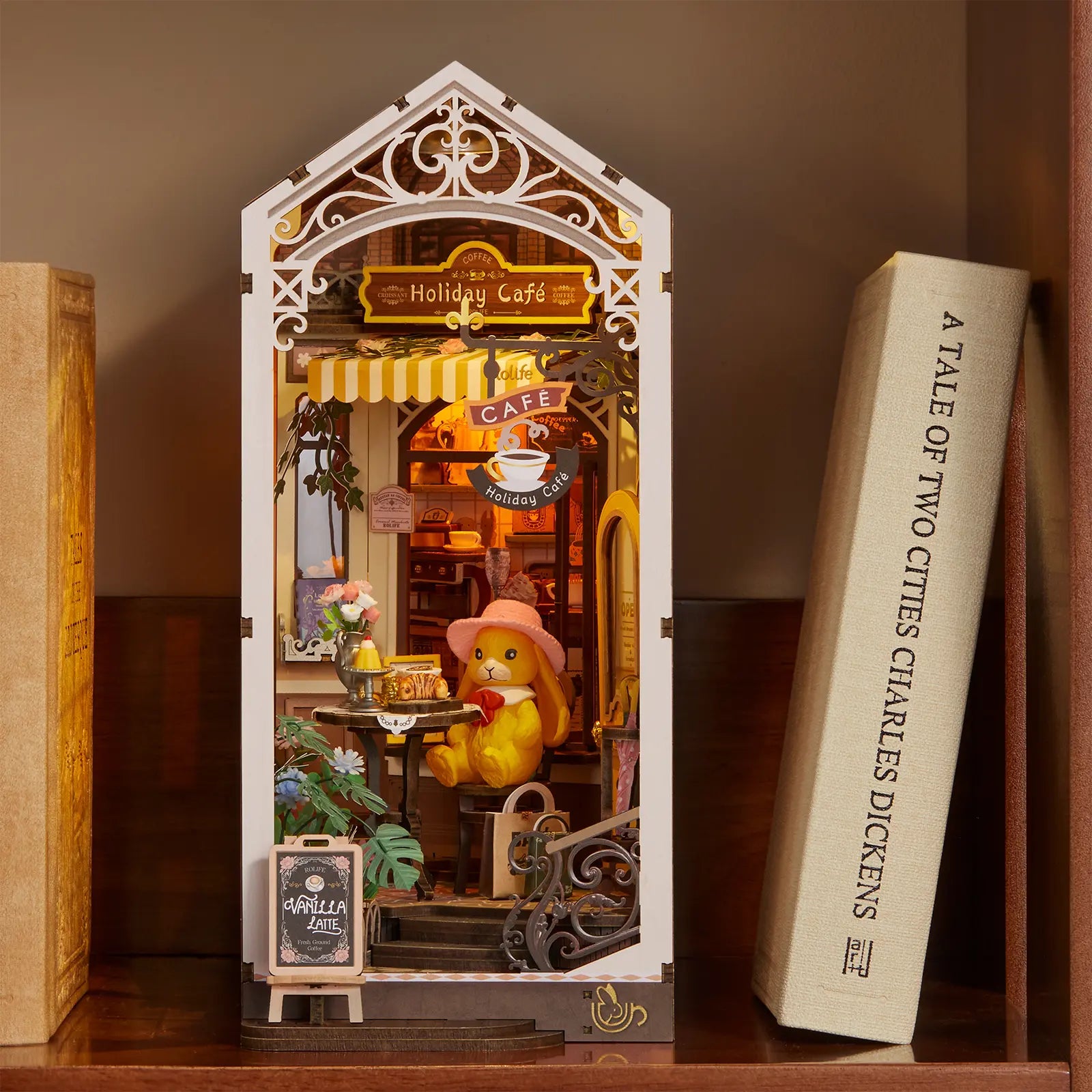 Atmosphärische Präsentation der Robotime Holiday Café, Book Nook Holzbausatz für eine Terrasse bei einem überdachten Café