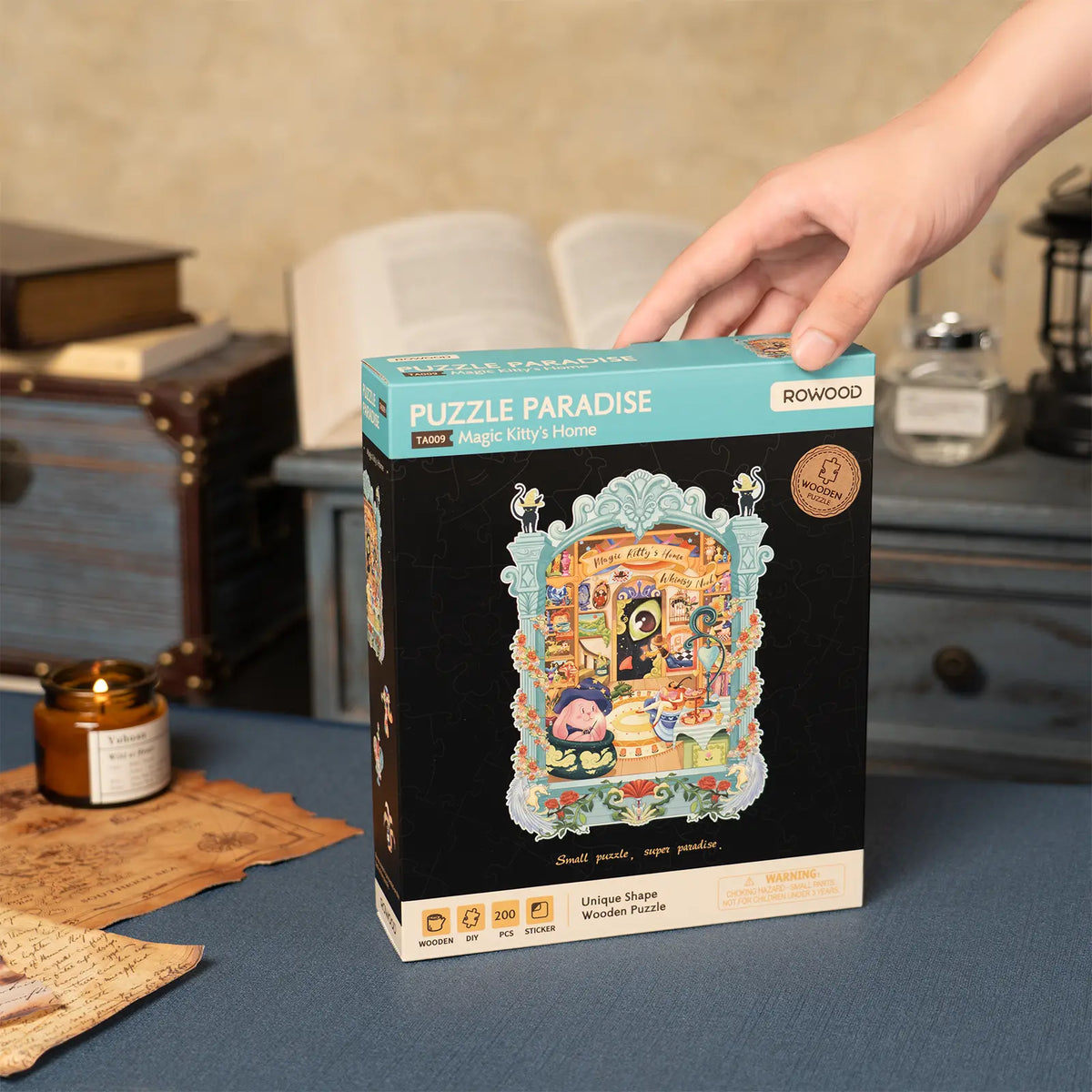 Stimmungsvolle Präsentation der Verpackung von Robotime Magic Kitty’s Home