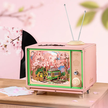 Atmosphärische Präsentation der Robotime Sakura Dreamy Tour, Holzbausatz eines Fernsehgeräts mit einer herumfahrenden Straßenbahn