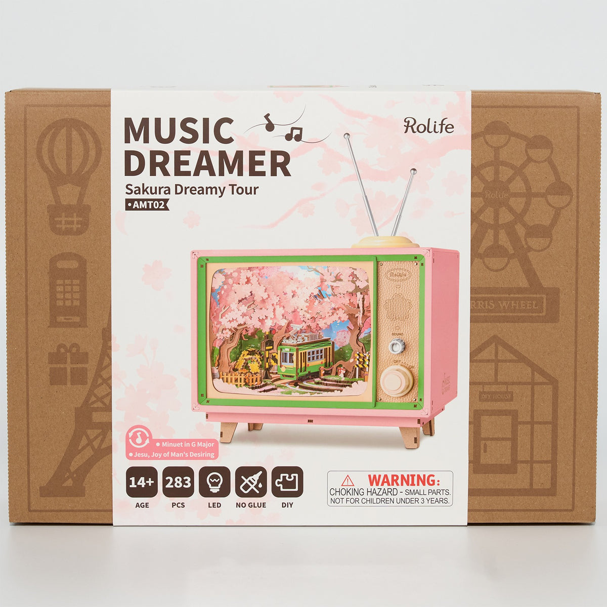 Vorderseite der Verpackung der Robotime Sakura Dreamy Tour, Holzbausatz eines Fernsehgeräts mit einer herumfahrenden Straßenbahn